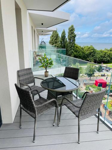 a patio with a table and chairs on a balcony at Sunrise Euronia in Międzyzdroje