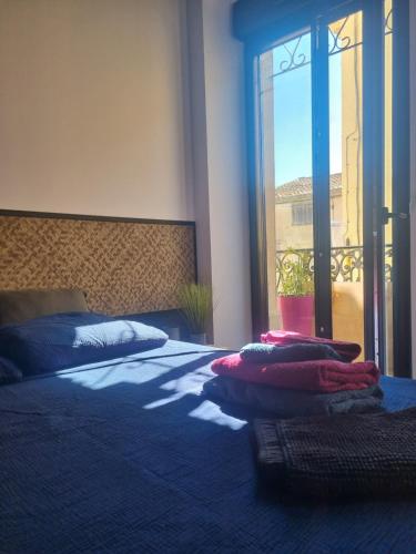 a bedroom with a bed with blue sheets and a window at La bulle carrée village in Lapalme