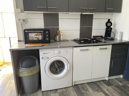 a kitchen with a washing machine and a microwave at F 36 Raimbaux 2 à 4 Personne 2 chambres Wifi Parking facile in Imphy