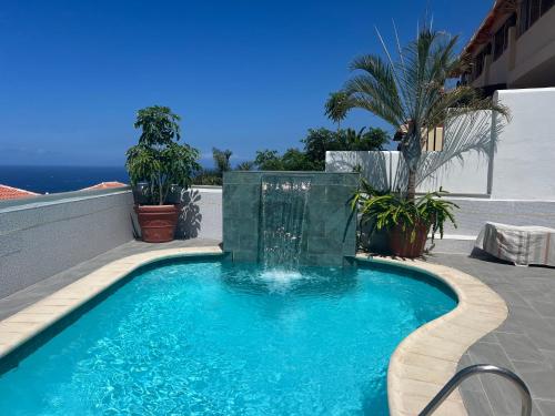 a swimming pool with a fountain on a patio at Adeje Deluxe Villas Santa Mónica in Adeje