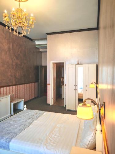 a bedroom with a large bed and a chandelier at Noblesse Palace Old Town by NF in Bucharest
