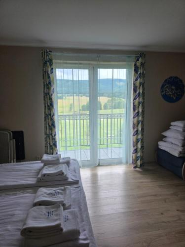 a bedroom with two beds and a large window at Jagodowy Ski&Spa DeLux apartamenty z widokiem na góry,4km od Zieleniec Ski Arena Podgrzewany basen zewnętrzny latem,bilard,Wi-Fi w cenie Restauracja,balia,sauna na miejscu in Lasowka