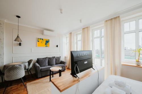 a living room with a tv and a couch at Klimatyczny Apartament na Bydgoskim Przedmieściu in Toruń