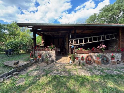 a building with flowers and plants in front of it at Етно кућа Нана Добра in Dimitrovgrad