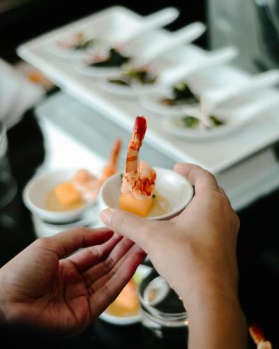 a person holding a piece of food on a plate at Best Western Premier La Grande Bandung in Bandung