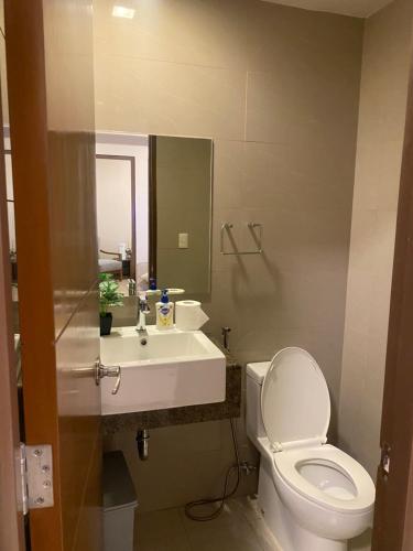 a bathroom with a white toilet and a sink at The Mactan Newtown Beach Condo in Lapu Lapu City