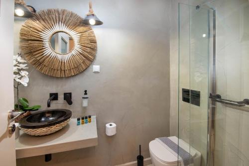 a bathroom with a sink and a mirror at Arokaria Studios by PaxosRetreats in Gaios