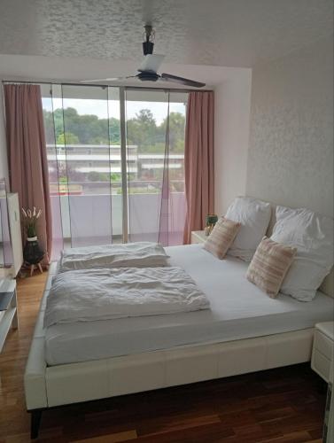 a large bed in a room with a large window at Luxus Business Apt mit Badewanne Balkon und Tiefgaragenstellplatz in Kerpen