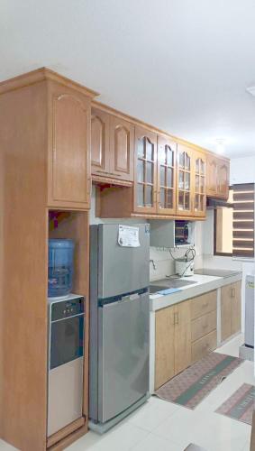 a kitchen with wooden cabinets and a stainless steel refrigerator at Alles One Oasis Condo Davao Near SM Mall with Wifi in Davao City