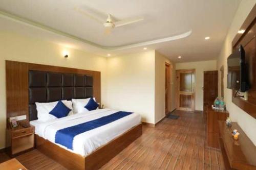 een slaapkamer met een groot bed met blauwe kussens bij Mahadev Villa Manali in Manāli