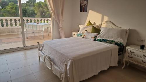 a bedroom with a bed and a view of a balcony at Villallop in Olivella