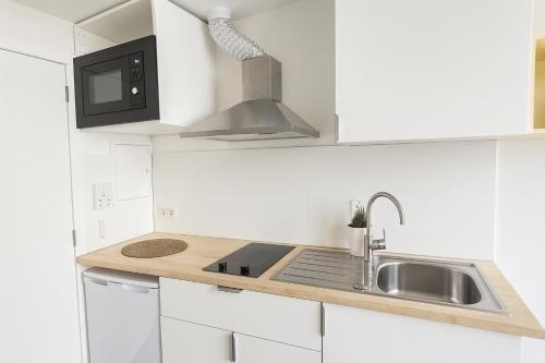 a white kitchen with a sink and a microwave at SWeet studio In Bruxelles in Brussels