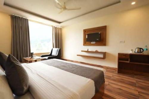 een hotelkamer met een bed en een televisie bij Mahadev Villa Manali in Manāli