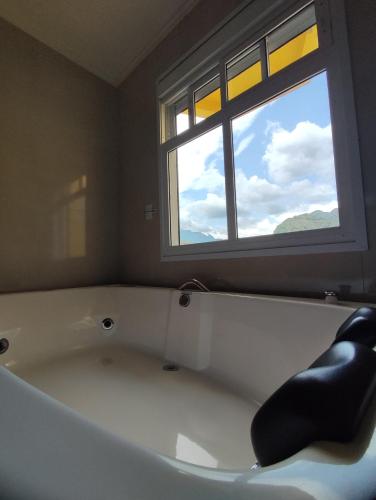 a bath tub in a bathroom with a window at Hotel Du Rastro in Louro Müller