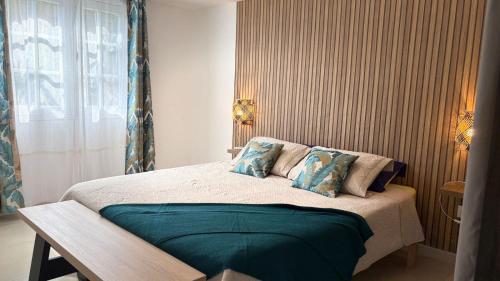 a bedroom with a large bed with blue pillows at Fleurs de mangue in Saint-Louis