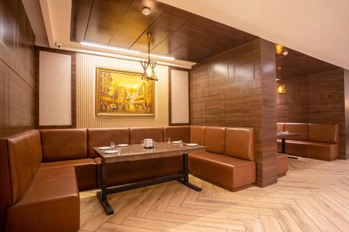 a restaurant with brown leather booths and a table at SANDOZ Pribson Hotel near Golden Temple in Amritsar