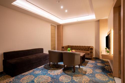 a living room with a couch and a table at SANDOZ Pribson Hotel near Golden Temple in Amritsar