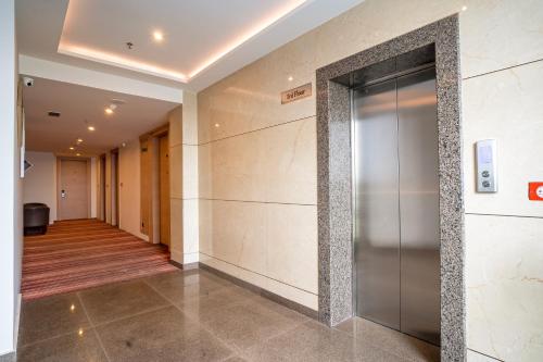 a hallway with an elevator in a building at SANDOZ Pribson Hotel near Golden Temple in Amritsar