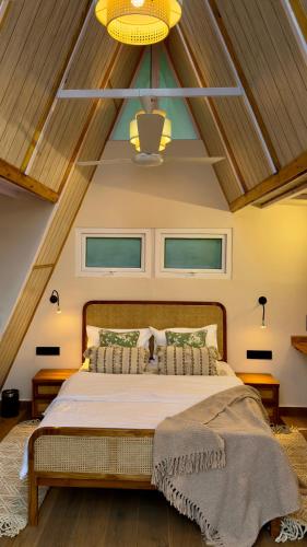 a bedroom with a large bed with a wooden ceiling at SHIVAYA since 1953 in Mukteswar