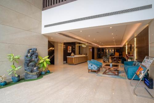 a lobby of a hotel with blue chairs at SANDOZ Pribson Hotel near Golden Temple in Amritsar