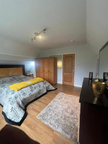 a bedroom with a bed with a yellow blanket on it at Zen suite in Oadby
