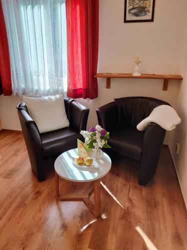 a living room with two chairs and a coffee table at Pension im Gesundbrunnental in Bad Freienwalde