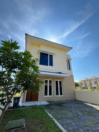 a white house with a tree in front of it at Alya Villa Syariah in Sidoarjo