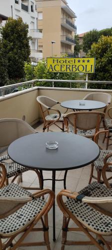 a table and chairs on a balcony with tables and chairs at Hotel Acerboli in Rimini