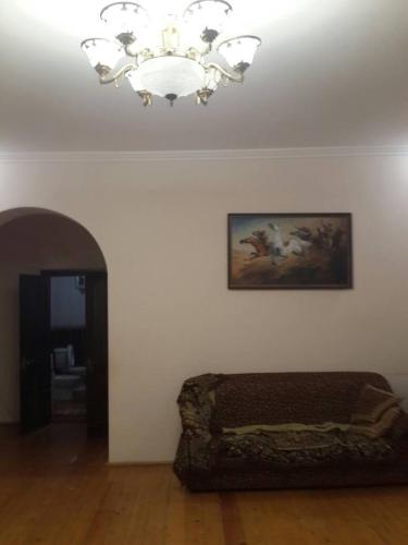 a living room with a chandelier and a couch at Talas guest house in Talas
