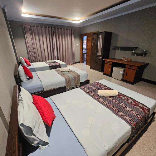 a hotel room with two beds and a desk at Ridho Malik Hotel in Bumbang