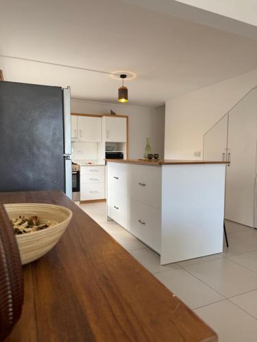 a kitchen with white cabinets and a wooden table at Le Nid du Dodo in Albion