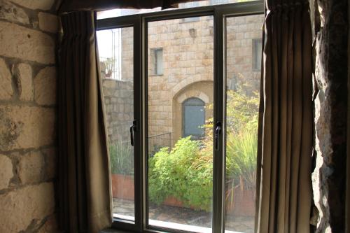 a window with a view of a brick building at Artists' Colony Inn Zefat in Safed