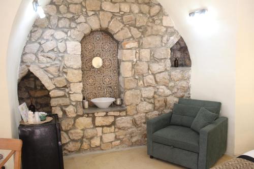 a stone wall with a chair in a room at Artists' Colony Inn Zefat in Safed