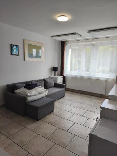 a living room with a couch and a tile floor at Leśna Przystań in Rewal