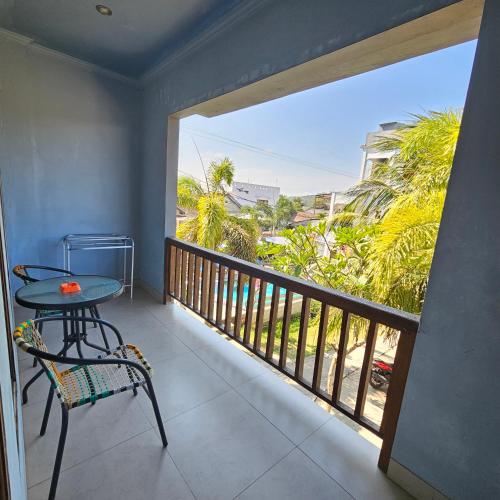 a balcony with a table and a view of the ocean at Ridho Malik Hotel in Bumbang