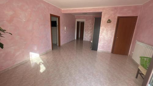 an empty room with pink walls and a tile floor at B&B Dimora Saracena in San Giuliano di Puglia