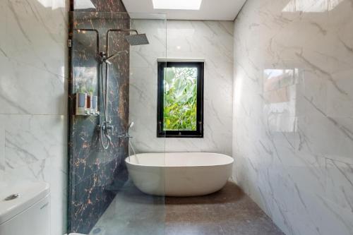 a bathroom with a bath tub and a window at ND LOFT 2 by Kasta Hospitality in Canggu