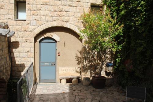 an entrance to a stone building with a blue door at Artists' Colony Inn Zefat in Safed