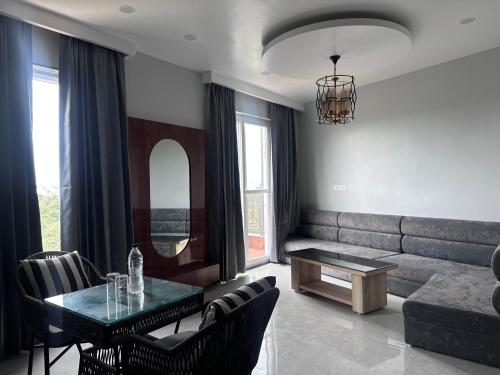 a living room with a couch and a table and chairs at Hotel Savaya Luxury Stay Near AIIMS Rishikesh in Rishīkesh