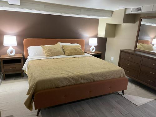 a bedroom with a bed with two lamps and a mirror at Ripple Avenue Suites Suite B in Indianapolis