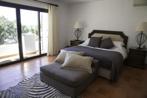 ein Schlafzimmer mit einem Bett und einer Couch darin in der Unterkunft Dreamy 4 Bedroom Villa in Valverde City 1014 in Cala Llonga