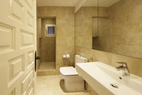 ein Badezimmer mit Toilette, Waschbecken und Spiegel in der Unterkunft Dreamy 4 Bedroom Villa in Valverde City 1014 in Cala Llonga