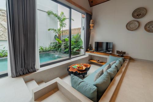 a living room with a couch and a table at Greha Natha Villa Ubud in Ubud