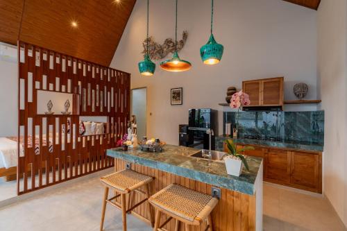 a kitchen with a counter and a fish tank at Greha Natha Villa Ubud in Ubud