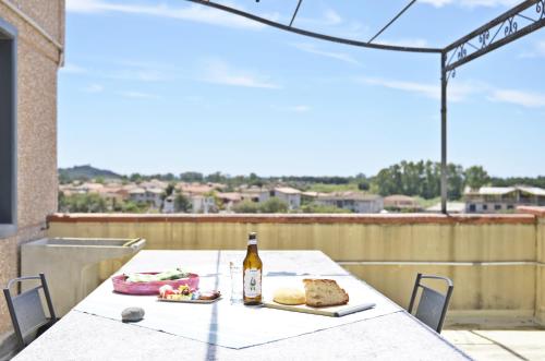 a table with a bottle of wine and food on a balcony at Casa Vacanza Viale Arbatax in Tortolì