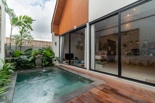 an indoor swimming pool in the middle of a house at Greha Natha Villa Ubud in Ubud