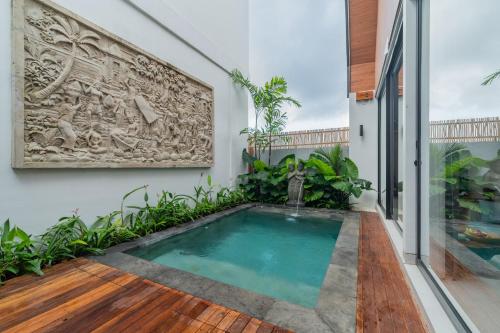 a swimming pool in the middle of a house at Greha Natha Villa Ubud in Ubud