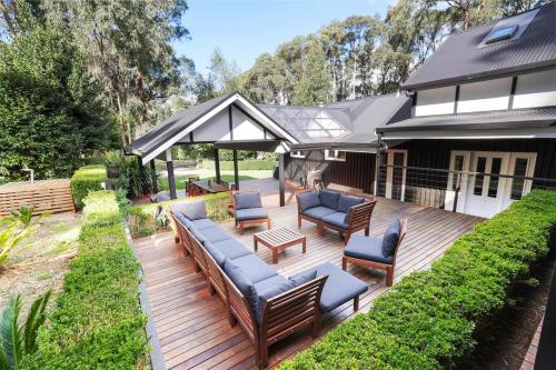 a wooden deck with benches and chairs on a house at Best of Yarra Valley and Kinglake National Park 