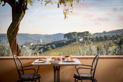 a table with food on a balcony with a view at Relais Vignale & Spa in Radda in Chianti