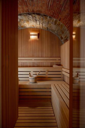 a sauna with a sink and a brick wall at Relais Vignale & Spa in Radda in Chianti